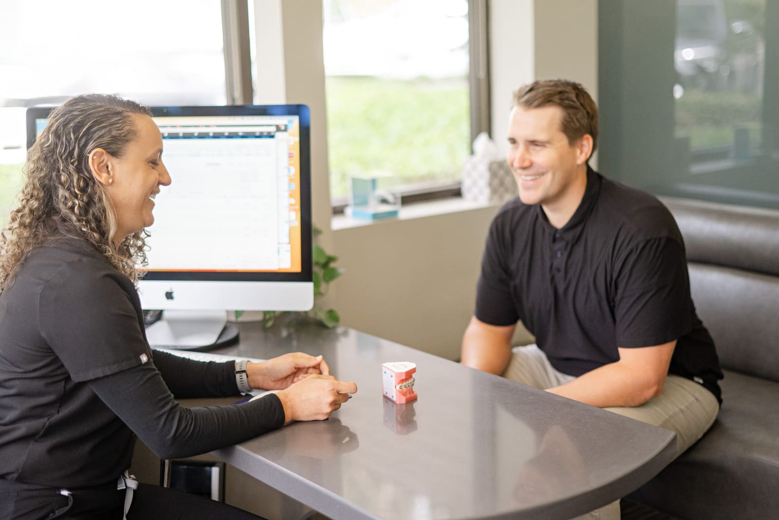 An adult patient smiling through his consultation with the Kinser Orthodontics treatment coordinator