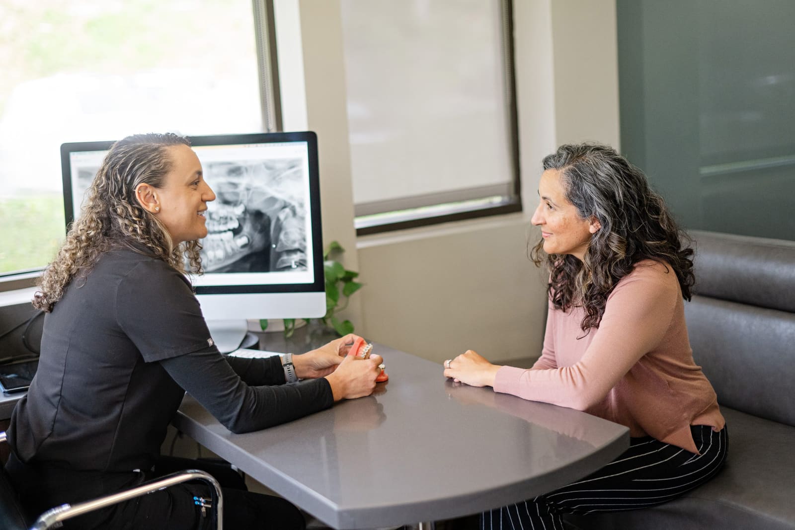 An adult patient reviewing her digital X-ray with a Kinser Orthodontics team member