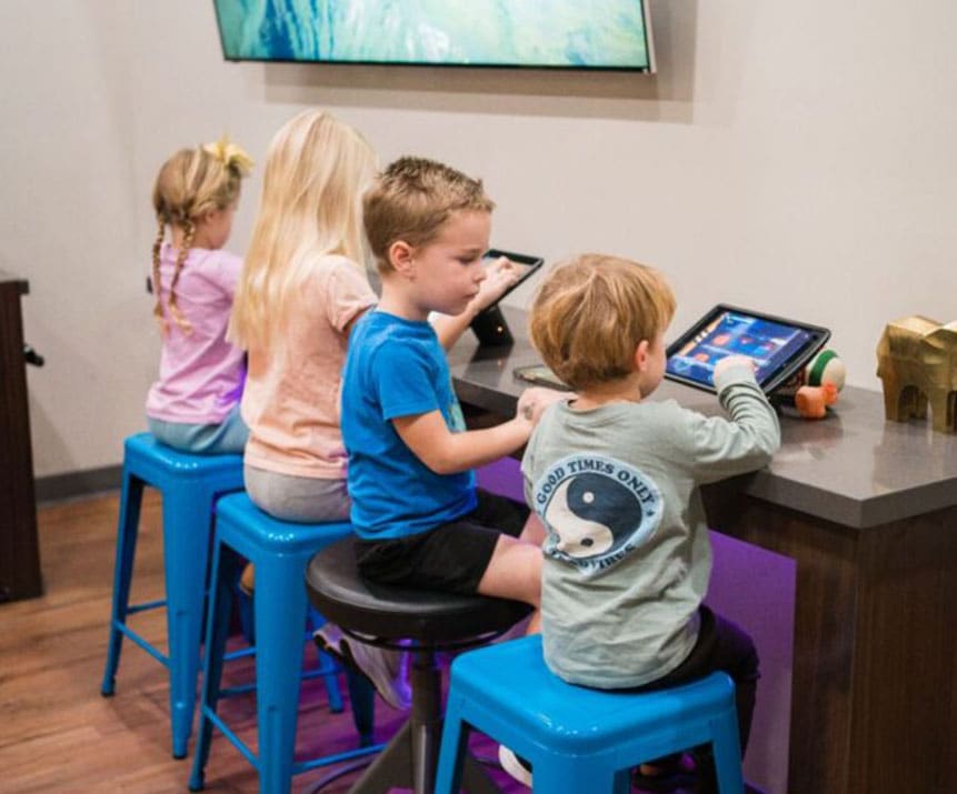 Young kids playing at the iPad bar in the Kinser Orthodontics waiting area