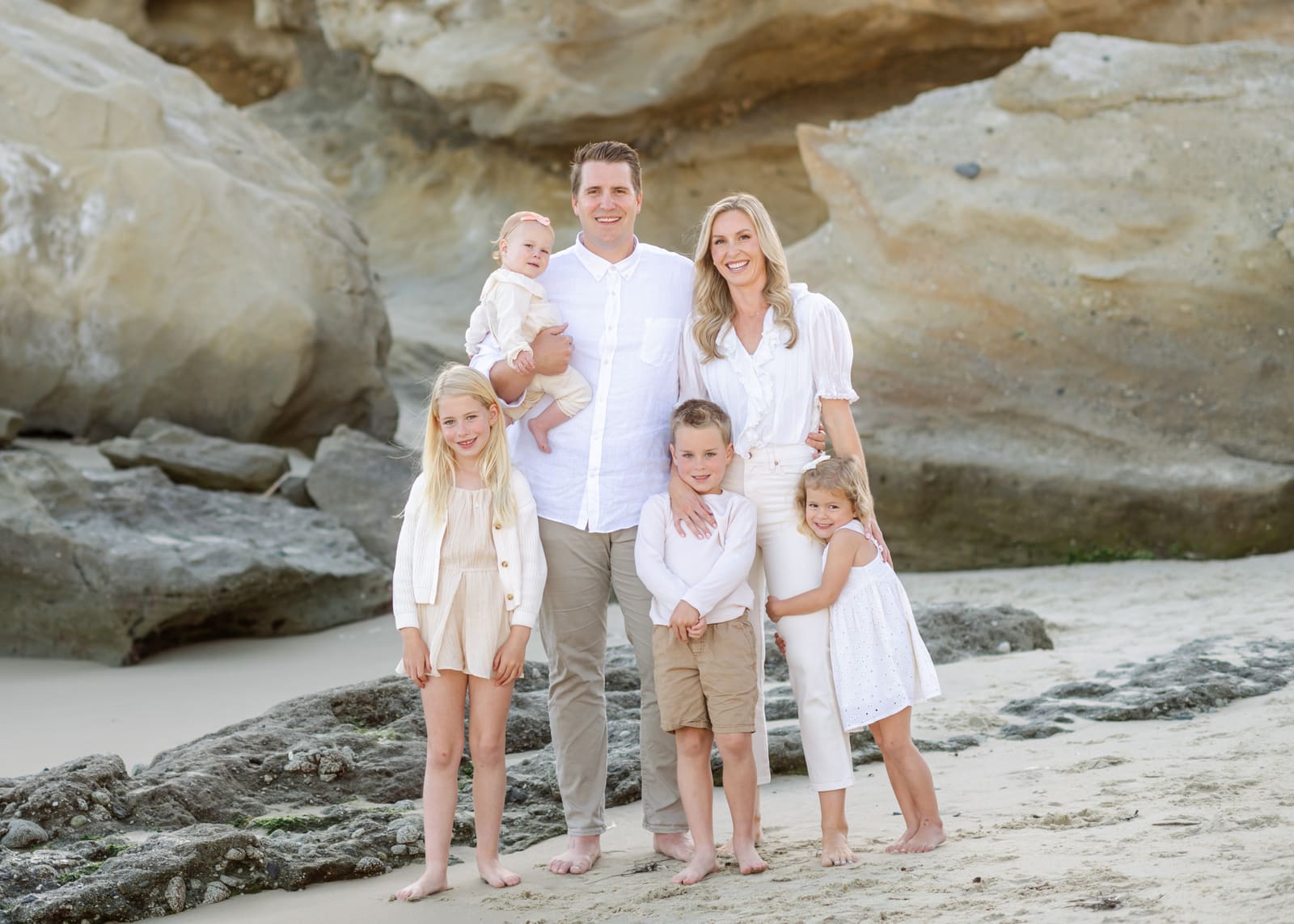 Dr. Kinser with his wife and four kids on the rocks at Laguna Beach