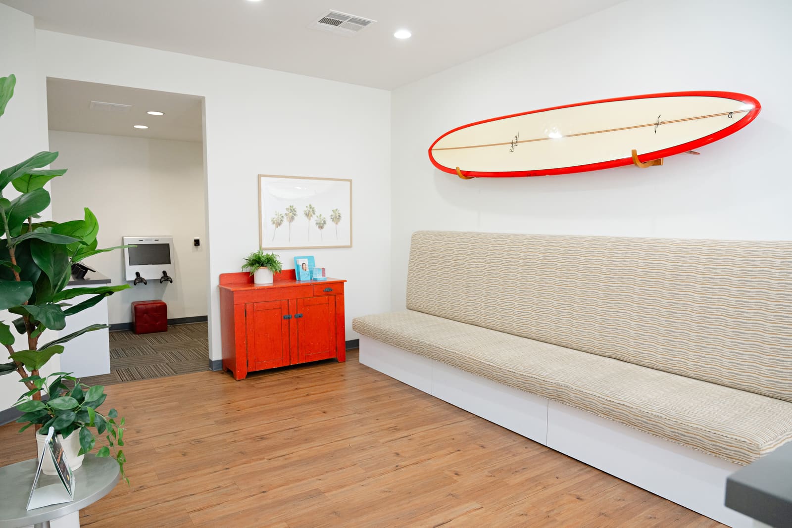 The waiting area at our Laguna Beach office with its red surfboard