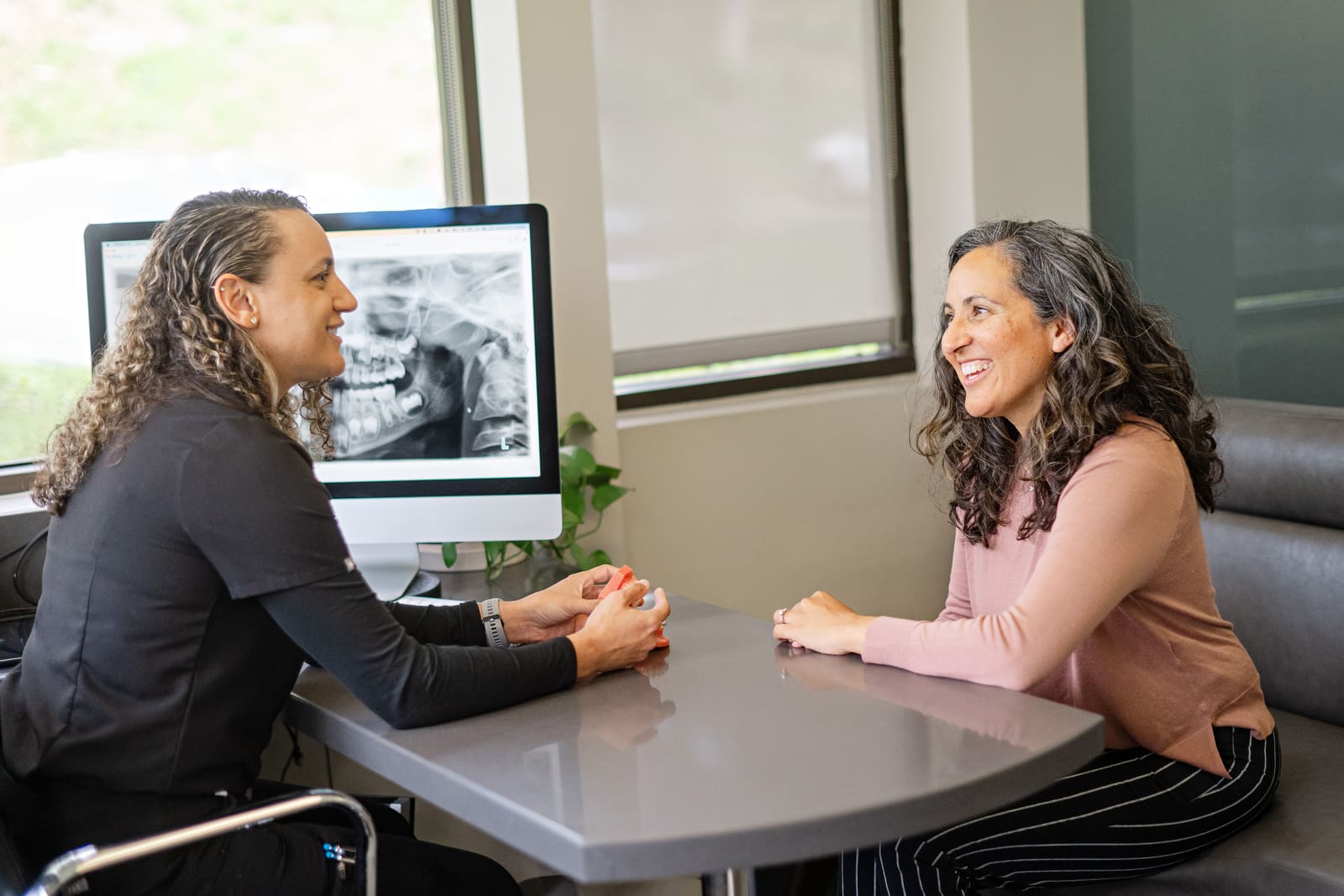A Kinser Orthodontics team member talking through treatment options with an adult patient