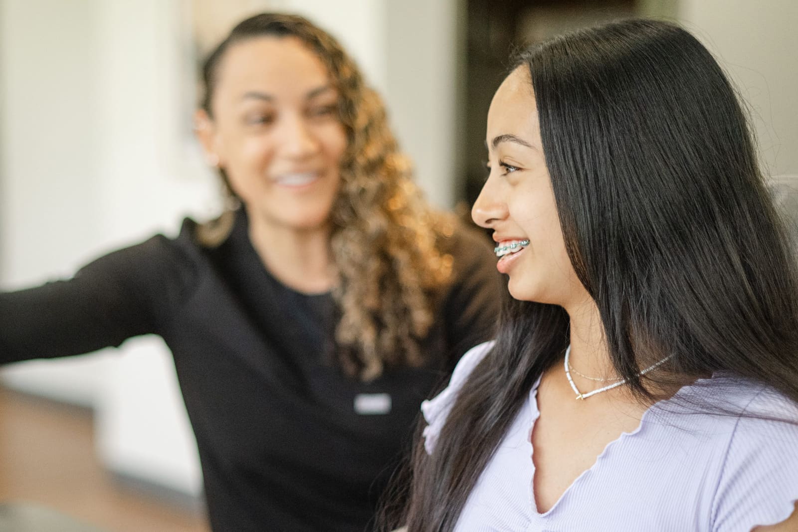 A teen patient with metal braces laughing during her appointment