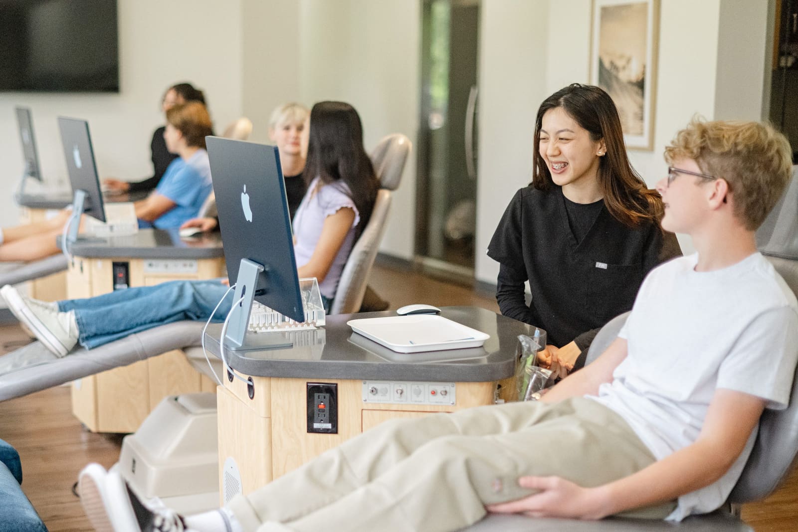 Two teen patients laughing in the treatment chairs at Kinser Orthodontics